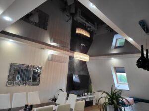 Czarny połyskowy sufit napinany w jadalni na poddaszu (Radom) Efektowny czarny połyskowy sufit napinany na poddaszu w jadalni z dwoma kryształowymi lampami – realizacja ABOR serwis Radom